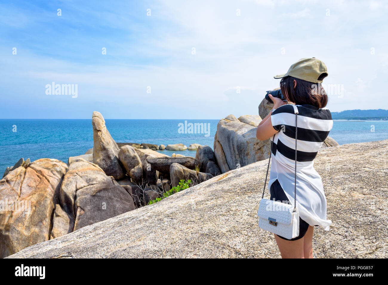 Junge Frau mit einer DSLR-Kamera zu Fotografie der Hin Ta Hin Yai und schöne Natur Landschaft von blauem Meer und Himmel im Sommer Reisen bei Ko Stockfoto