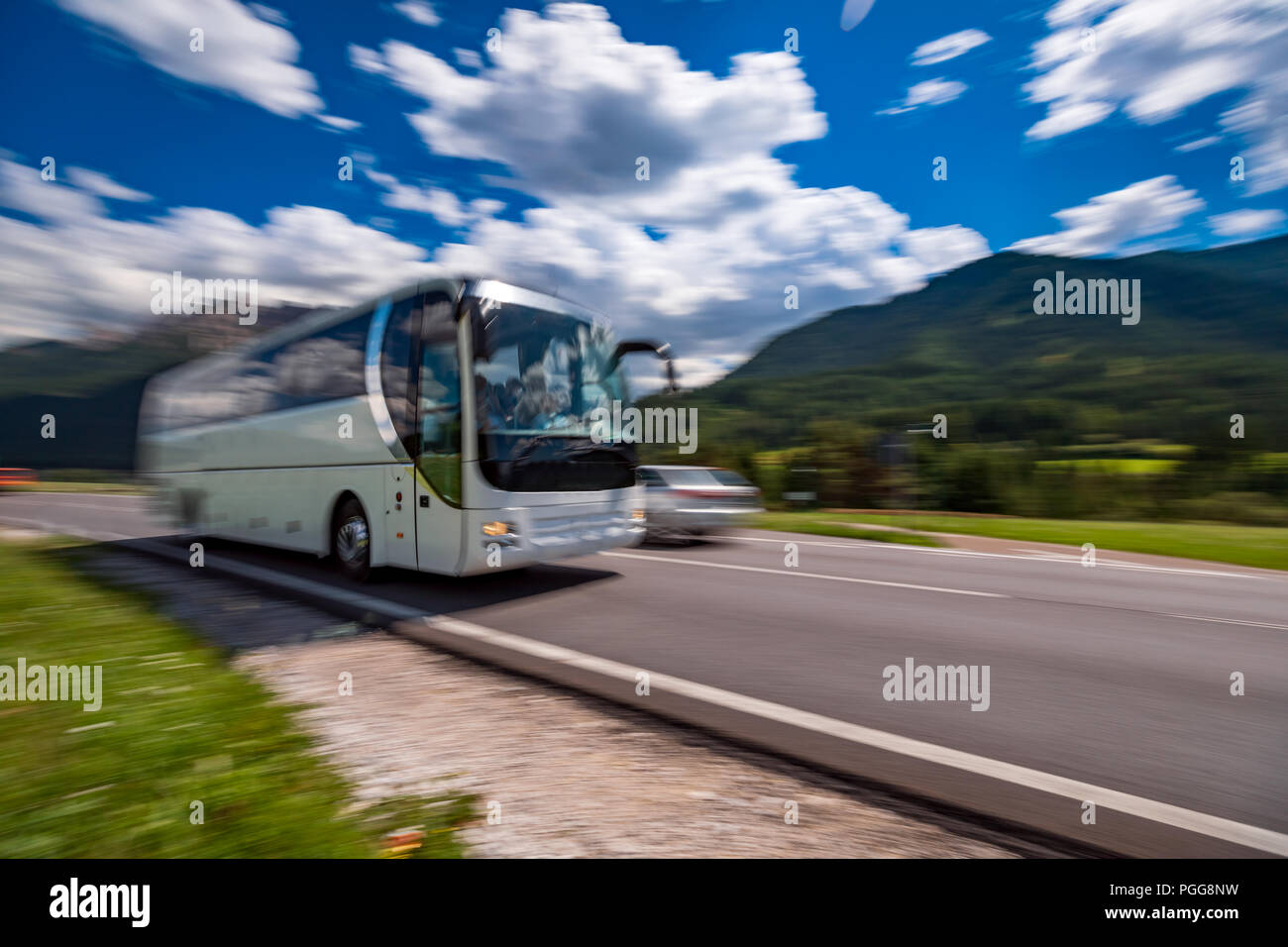 Touristische Bus unterwegs auf der Straße, im Hintergrund die Dolomiten Alpen Italien. Warnung - authentische Aufnahmen gibt es eine Bewegungsunschärfe. Stockfoto