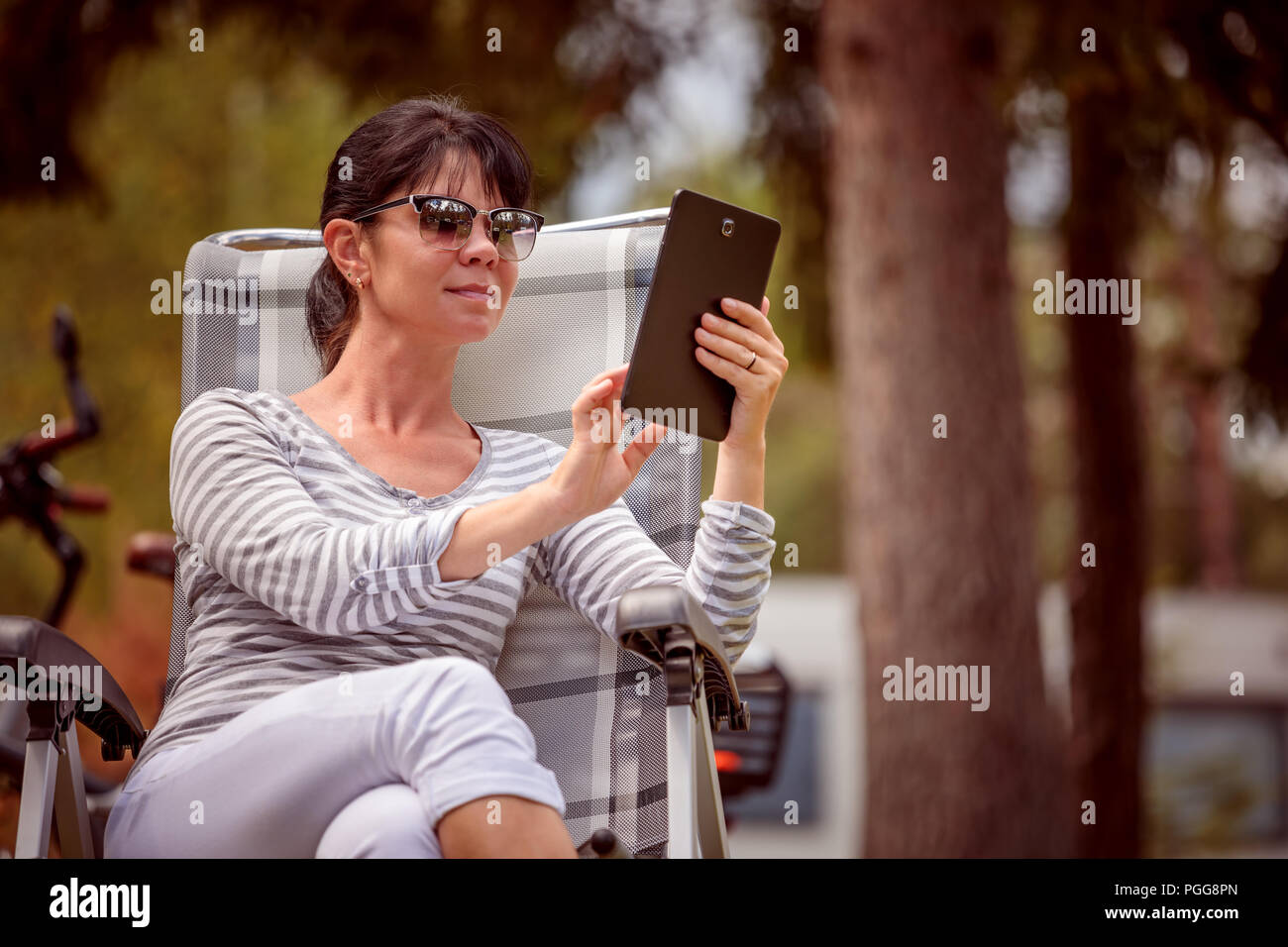 Frau mit Blick auf die Tafel in der Nähe des Camping. Caravan Auto Urlaub. Familie Urlaub Reisen, Urlaub im Reisemobil RV. Wi-fi Verbindung Informatio Stockfoto Frau mit Blick auf die Tafel in der Nähe des Camping. Caravan Auto Urlaub. Familie Urlaub Reisen, Urlaub im Reisemobil RV. Wi-fi Verbindung Informatio Stockfoto