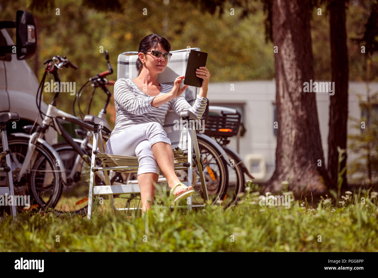 Frau mit Blick auf die Tafel in der Nähe des Camping. Caravan Auto Urlaub. Familie Urlaub Reisen, Urlaub im Reisemobil RV. Wi-fi Verbindung Informatio Stockfoto Frau mit Blick auf die Tafel in der Nähe des Camping. Caravan Auto Urlaub. Familie Urlaub Reisen, Urlaub im Reisemobil RV. Wi-fi Verbindung Informatio Stockfoto