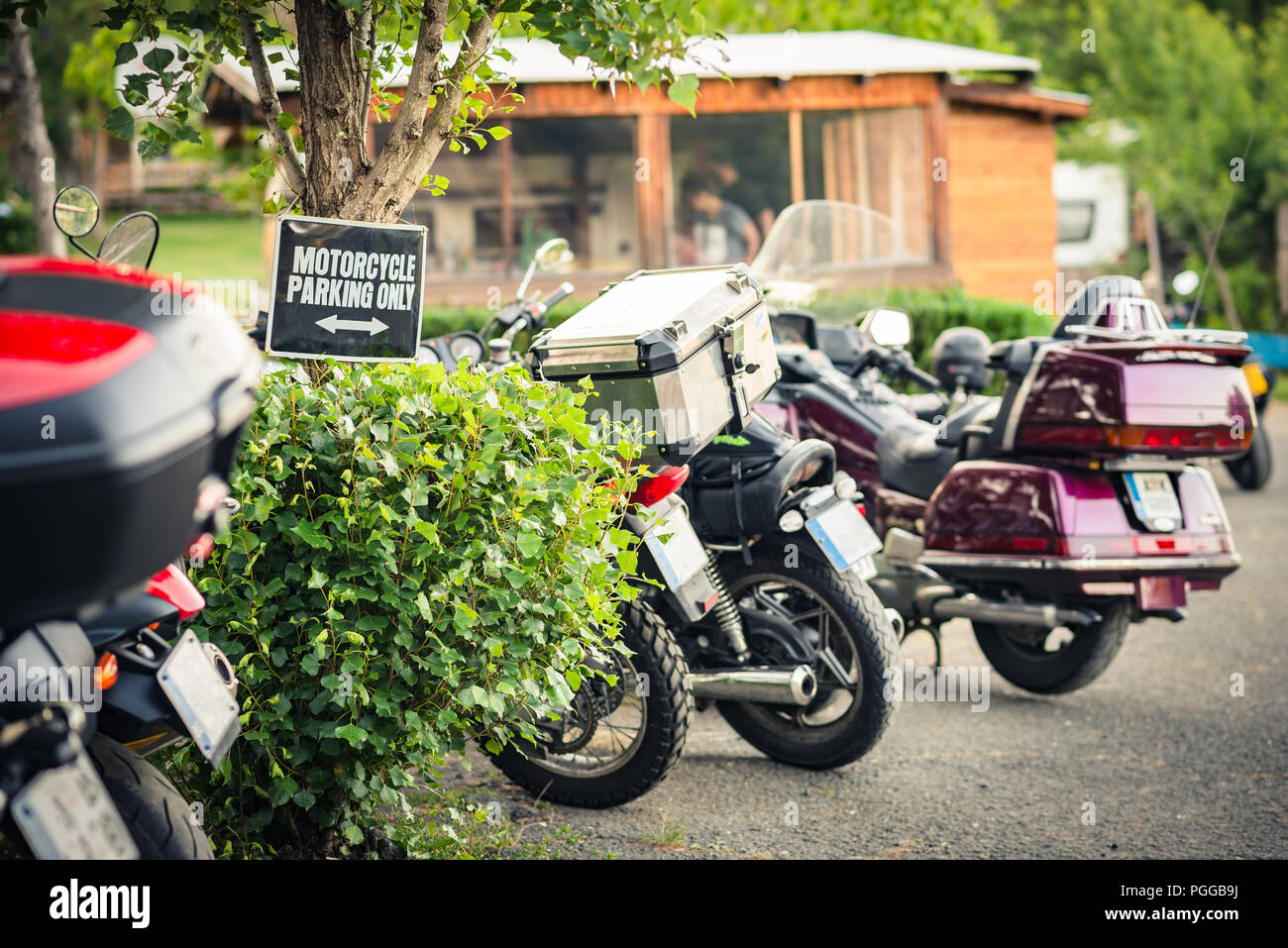 Eine Zeile mit geparkte Motorräder in einen Campingplatz mit einem Motorrad parken nur" zu unterzeichnen. Stockfoto