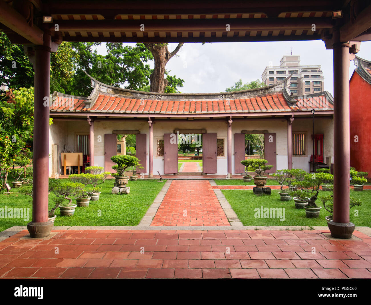 Im chinesischen Stil roten Tor und Tür mit roten Spalten in Konfuzius Tempel, die in der traditionellen chinesischen Architektur mit Bonsai Gasse in Tainan, Stockfoto