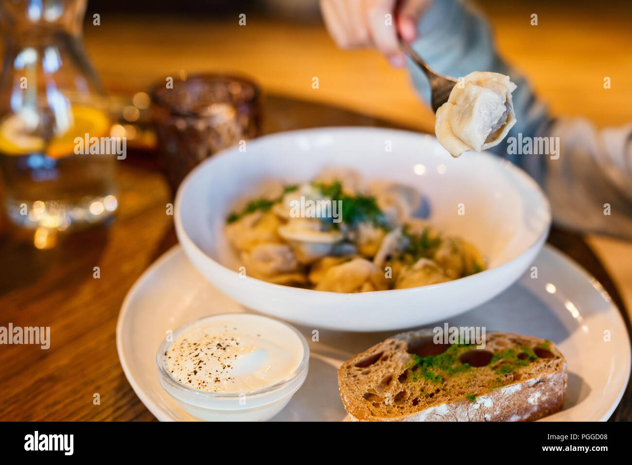 Hausgemachte Fleisch Knödel russische Pelmeni serviert mit Dill und Smetana im Restaurant Stockfoto
