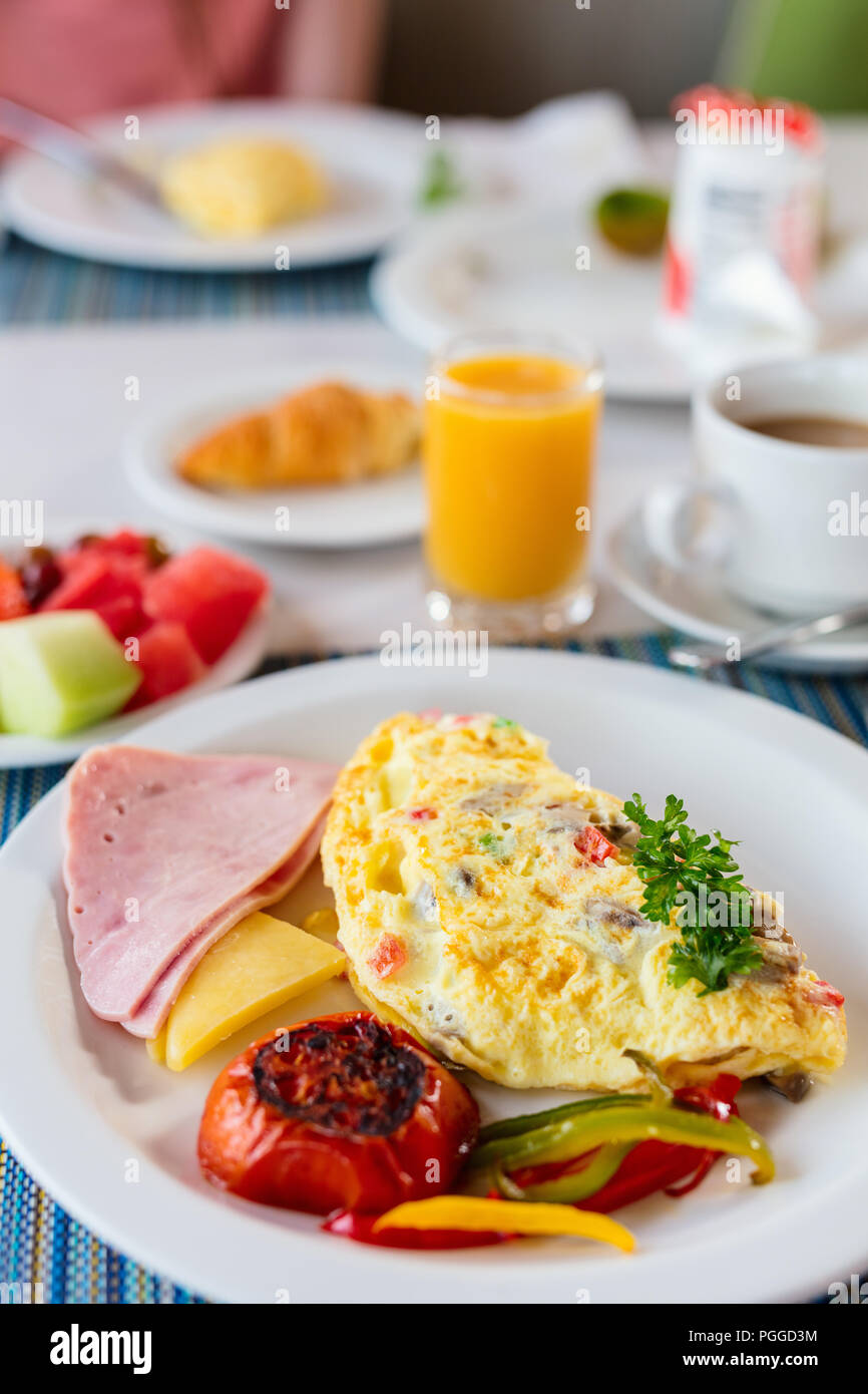 Köstliches Frühstück mit Omelette, Schinken und Gemüse Stockfoto