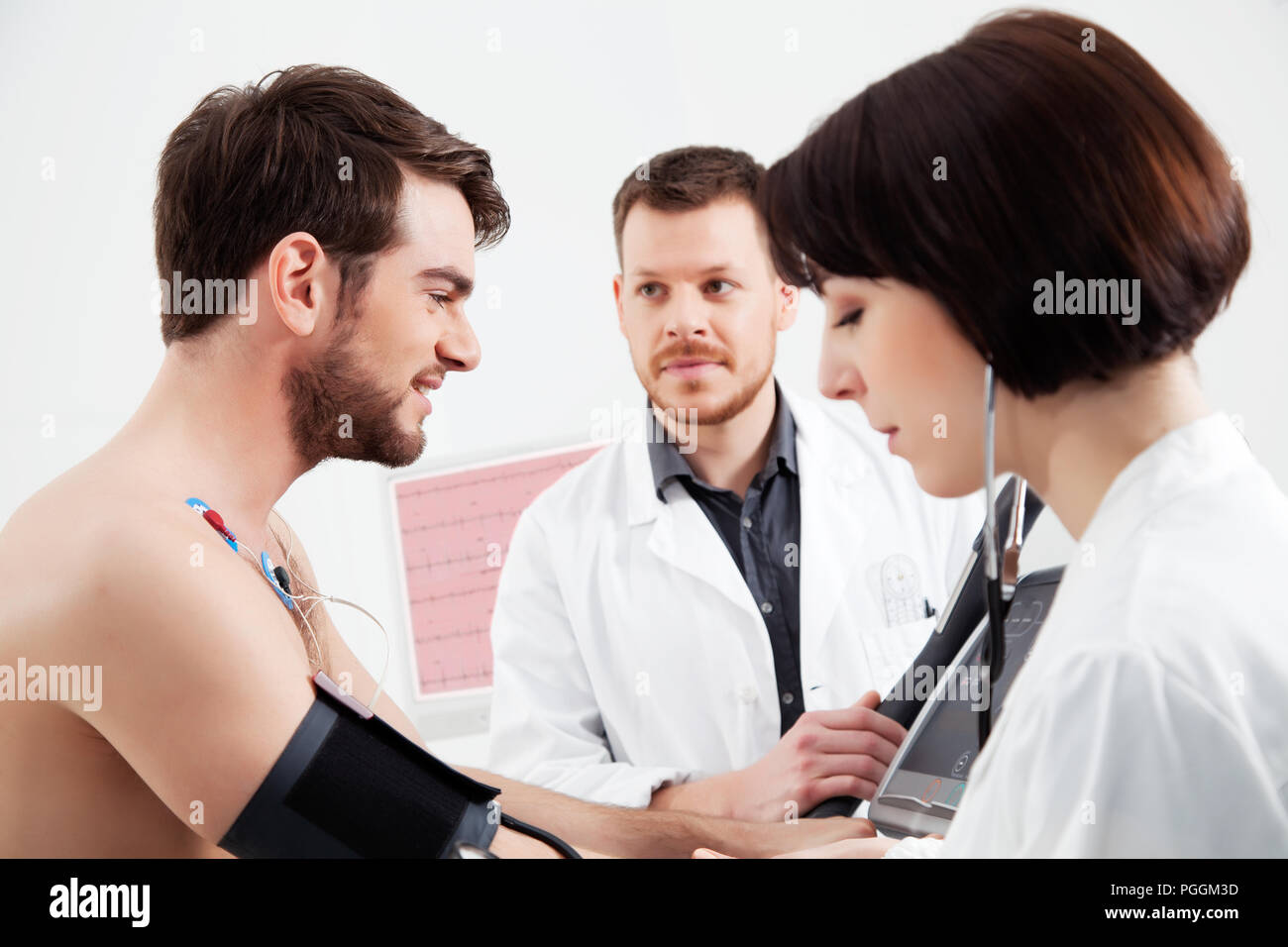 Kardiologe und Krankenschwester helfen dem Patienten während einer Herzbelastungsprobe Prüfung Stockfoto