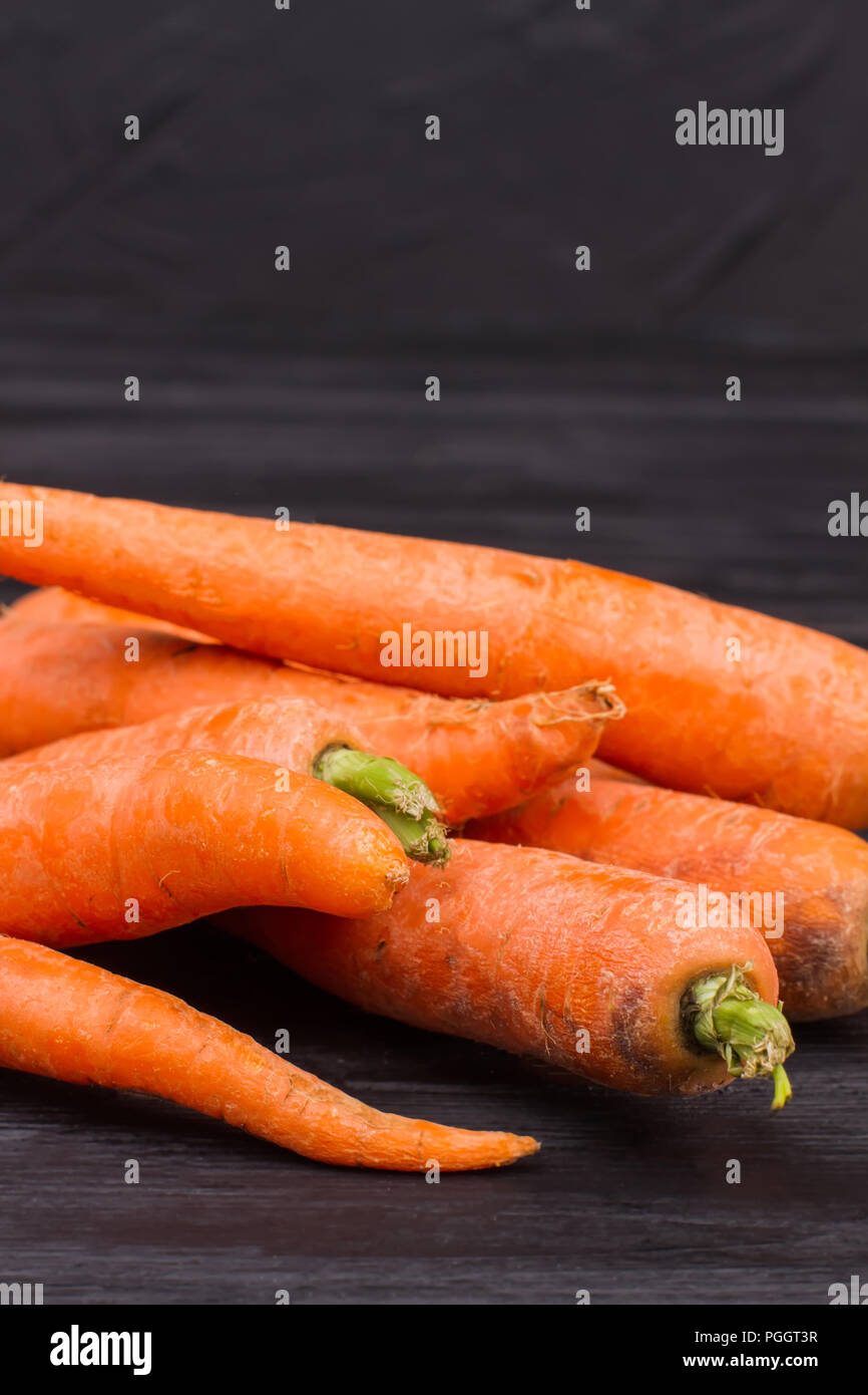 Haufen sauber reif Karotten. Close Up. Schreibtisch aus dunklem Holz Tisch  Hintergrund Stockfotografie - Alamy