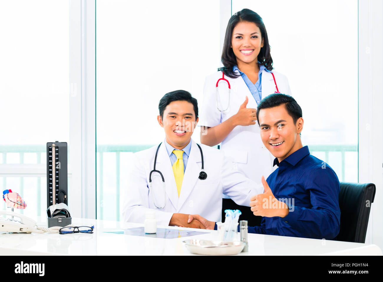 Asiatische Ärzte mit Patienten in der Arztpraxis oder Klinik ...