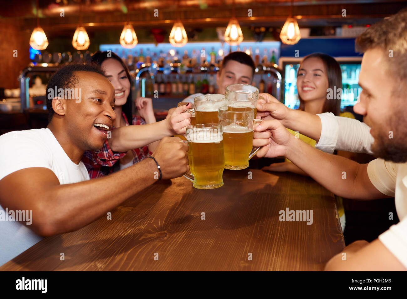 Gruppe der glücklichen Freunde Bier an Design Pub genießen, Toasten und zu lachen. Vier Jungs und zwei Mädels zusammen Spaß zu haben, Bier, das klirren Gläser Stockfoto