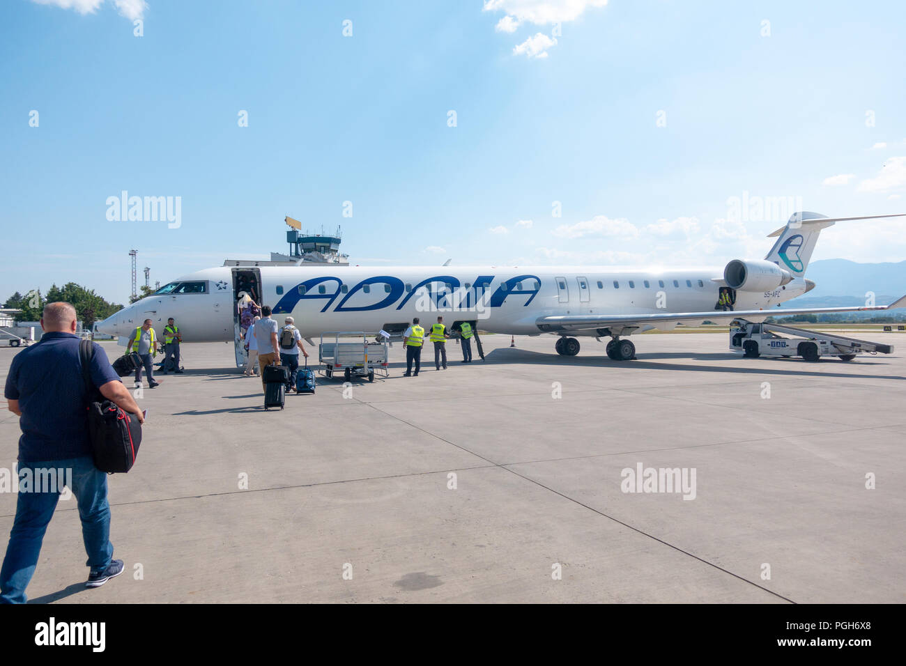 Skopje, Mazedonien - 25. August 2018: Passagiere Adria Airways Bombardier CRJ-900 Passenger Jet am Flughafen von Skopje nach Ljubljana. Adria ist Lokale Auto Stockfoto