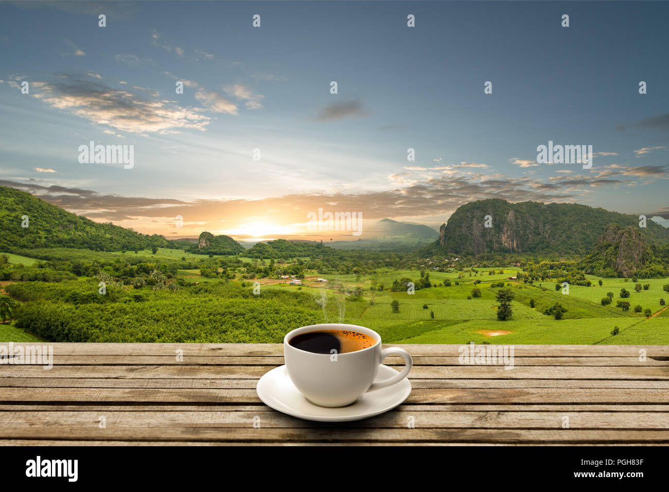Kaffeetasse auf Holztisch mit blauem Himmel und schönen Berg mit Sunrise Stockfoto