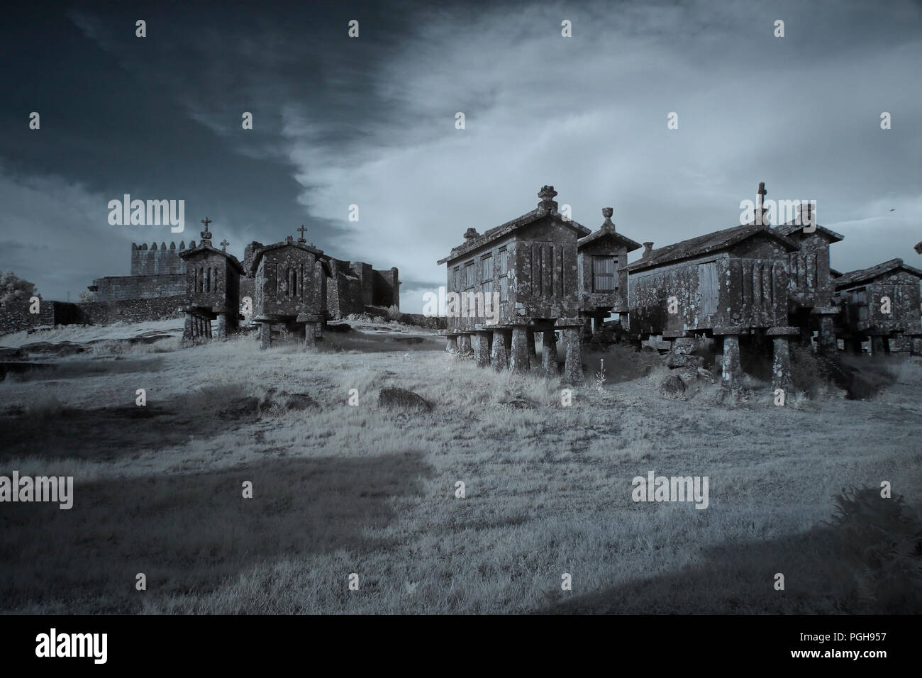 Lindoso Granit mais Getreidespeicher und der mittelalterlichen Burg, Dorf von Peneda Geres National Park, Northern Portugal. Ir-Filter verwendet. Stockfoto