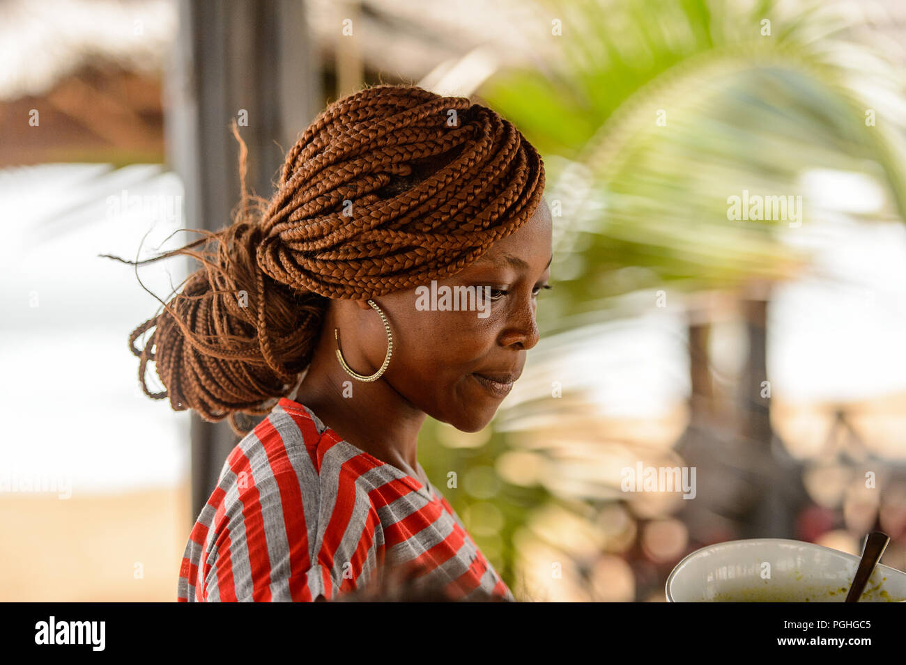 LOME, TOGO - Jan 9, 2017: Unbekannter togoische Frau in farbiges Shirt mit Zöpfen und Big earing. Togo Menschen leiden unter der Armut aufgrund der schlechten Econom Stockfoto