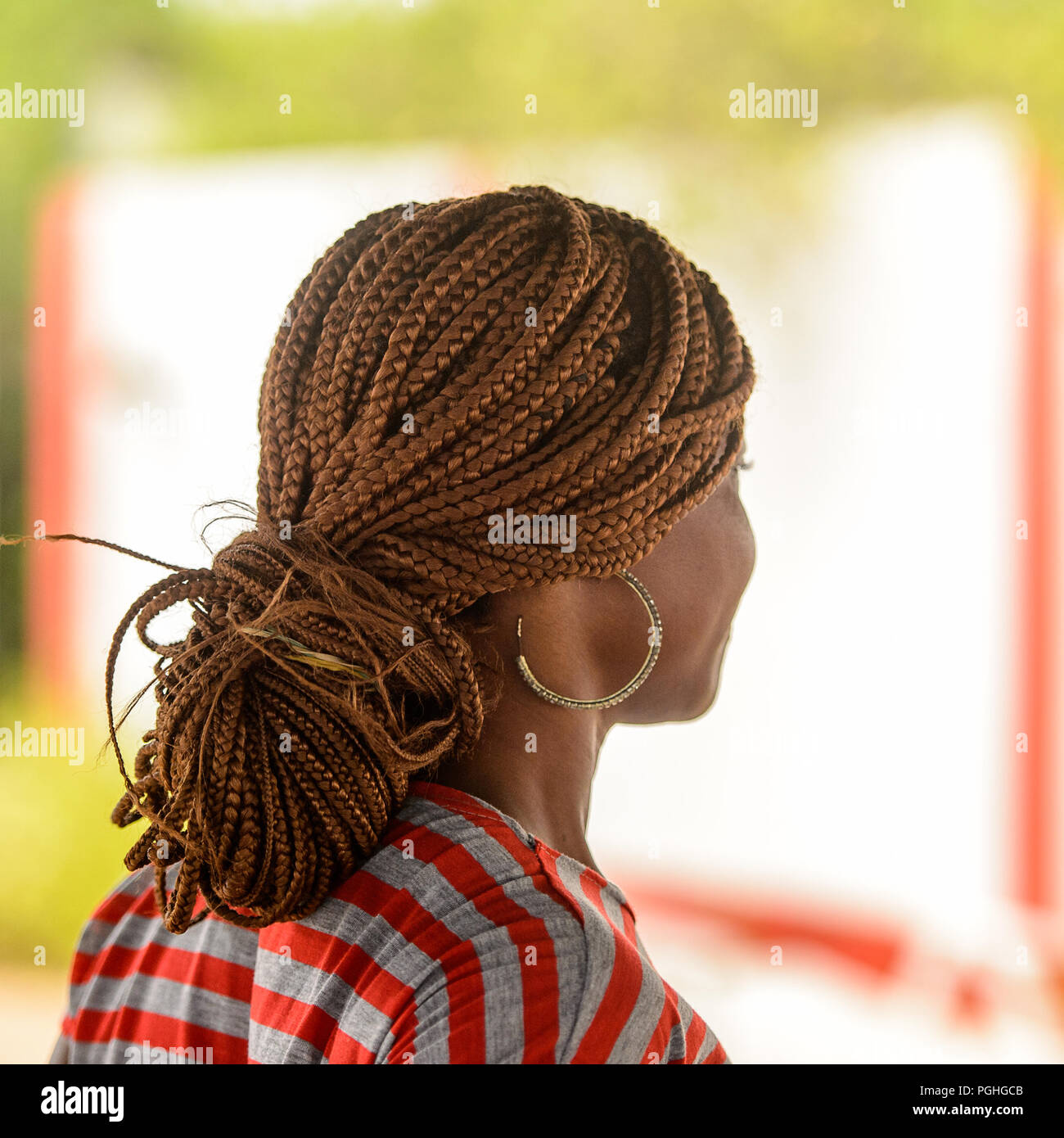 LOME, TOGO - Jan 9, 2017: Unbekannter togoische Frau in farbiges Shirt mit Zöpfen und Big earing. Togo Menschen leiden unter der Armut aufgrund der schlechten Econom Stockfoto