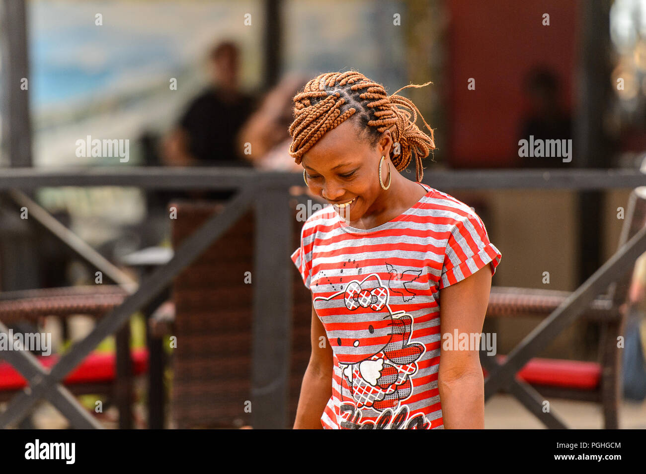 LOME, TOGO - Jan 9, 2017: Unbekannter togoische Frau in farbiges Shirt mit Zöpfen und Big earing. Togo Menschen leiden unter der Armut aufgrund der schlechten Econom Stockfoto