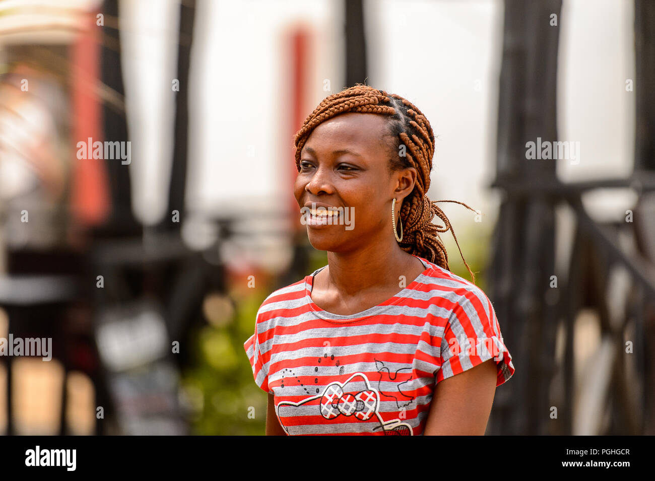 LOME, TOGO - Jan 9, 2017: Unbekannter togoische Frau in farbiges Shirt mit Zöpfen und Big earing. Togo Menschen leiden unter der Armut aufgrund der schlechten Econom Stockfoto