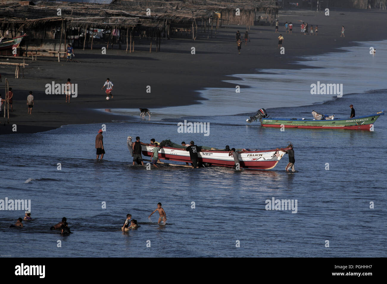 Fischer push Holzboot bis Sandstrand von Playa El Cuco, El Salvador Stockfoto