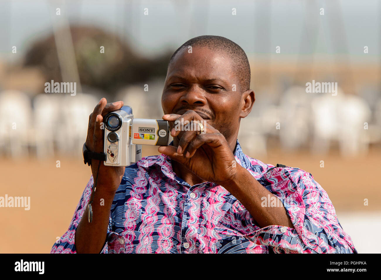 OUIDAH, BENIN - Jan 10, 2017: Unbekannter beninischen Mann mit Videokamera an der voodoo Festival, das jährlich im Januar gefeiert wird, 10. Stockfoto