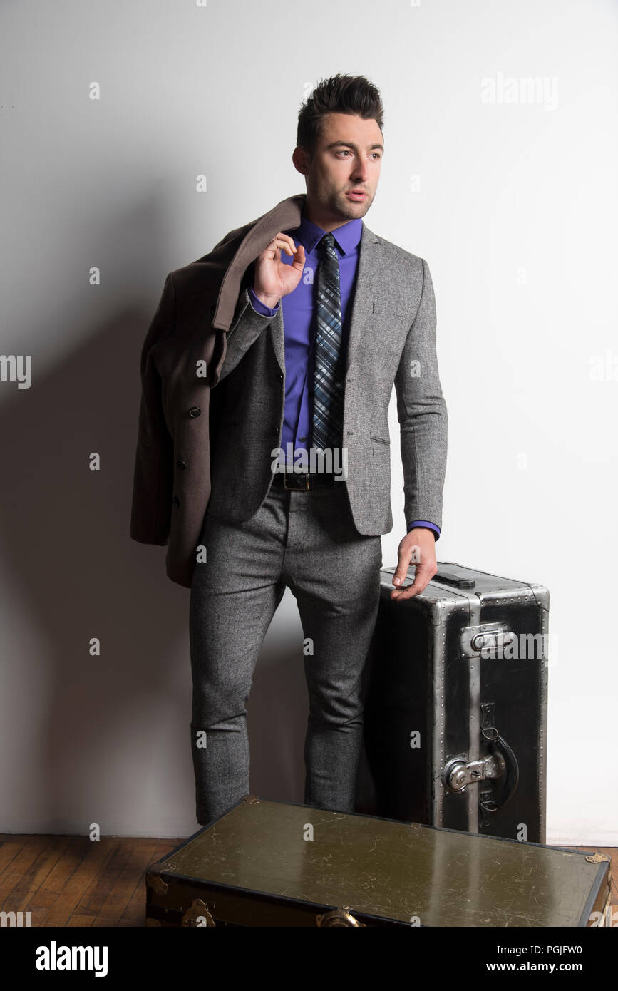 Ein schönes, gut gekleideter Mann stand neben Steamer Trunks. Exklusive Bild. Stockfoto
