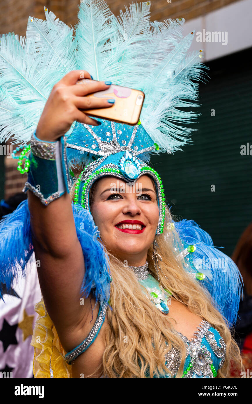 London, Vereinigtes Königreich. 27. August 2018. Eine Tänzerin aus der Paraiso Schule von Samba nimmt eine selfie vor der Parade an der Notting Hill Carnival, Europas größtem Straßenfest. Foto: Bettina Strenske/Alamy leben Nachrichten Stockfoto