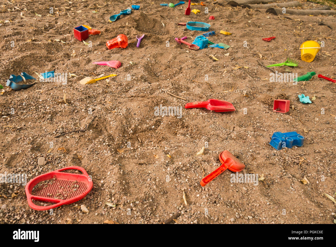 Buntes Plastikspielzeug auf dem Sand verstreut Stockfoto