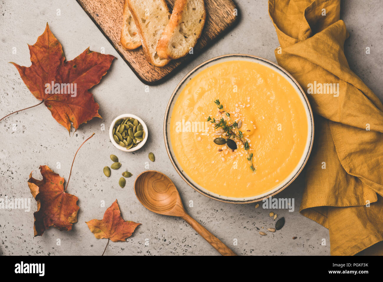 Kürbis creme Suppe in Schüssel auf konkreten Hintergrund. Vegan Vegetarisch Kürbissuppe. Herbst Komfort Essen. Ansicht von oben, getönten Bild Stockfoto