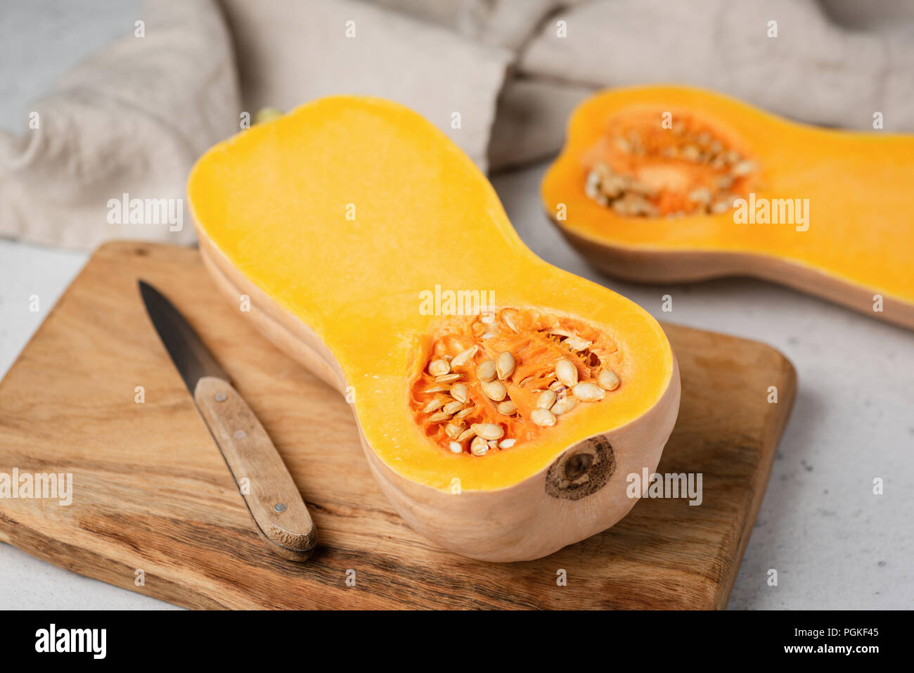 Butternut Kürbis halbieren auf Holz Schneidebrett. Vorbereitung von Pumpkin Pie, kürbissuppe. Herbst Komfort Essen kochen Stockfoto