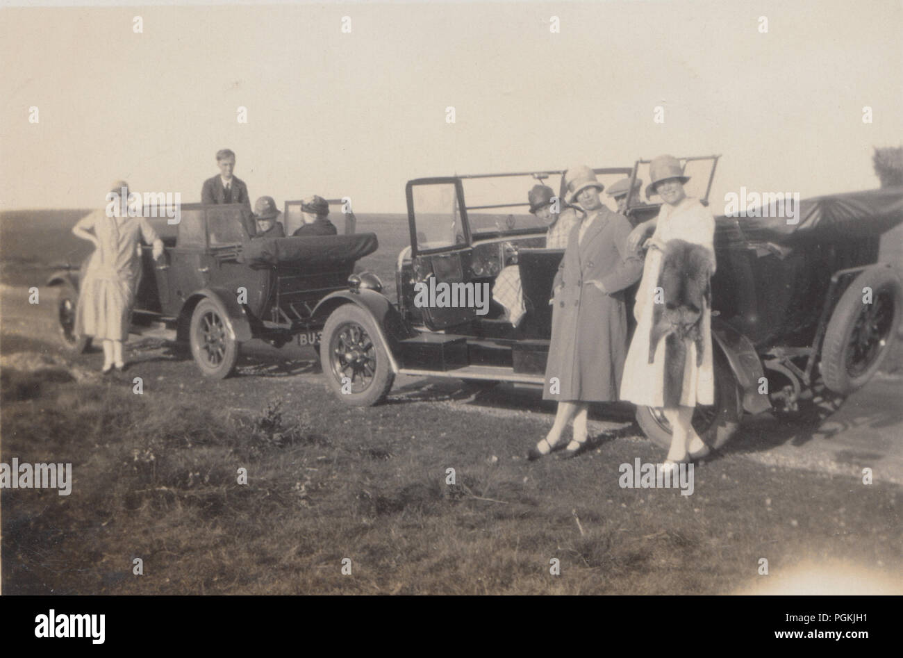 Foto von einem 1920er Modisch Gruppe mit Ihren zwei Oldtimer, bei einem Ausflug Stockfoto
