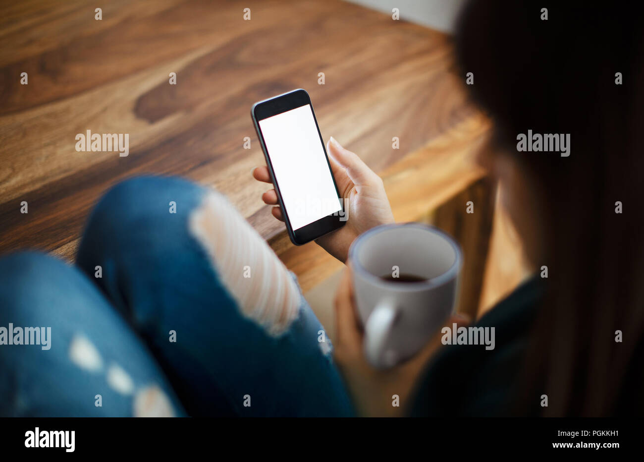 Frau mit Tasse Kaffee und Holztisch Stockfoto
