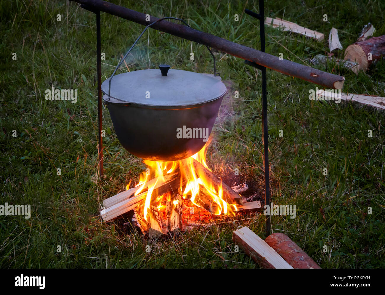 In einer Lichtung im Wald, am Abend zu einem Brand in einem Topf kochen. Stockfoto