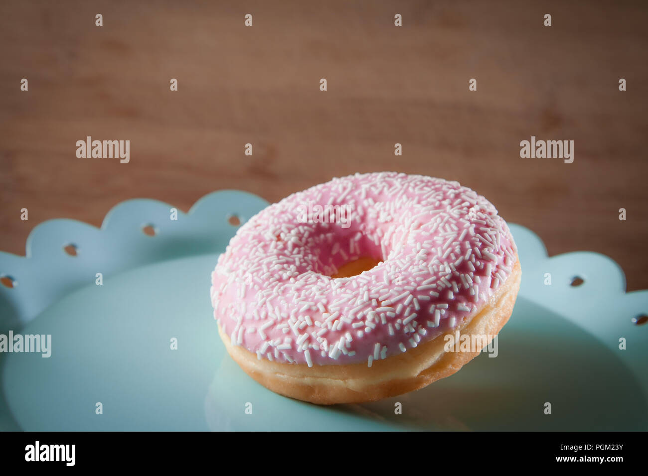 Rosa Donut auf Türkis Platte Stockfoto