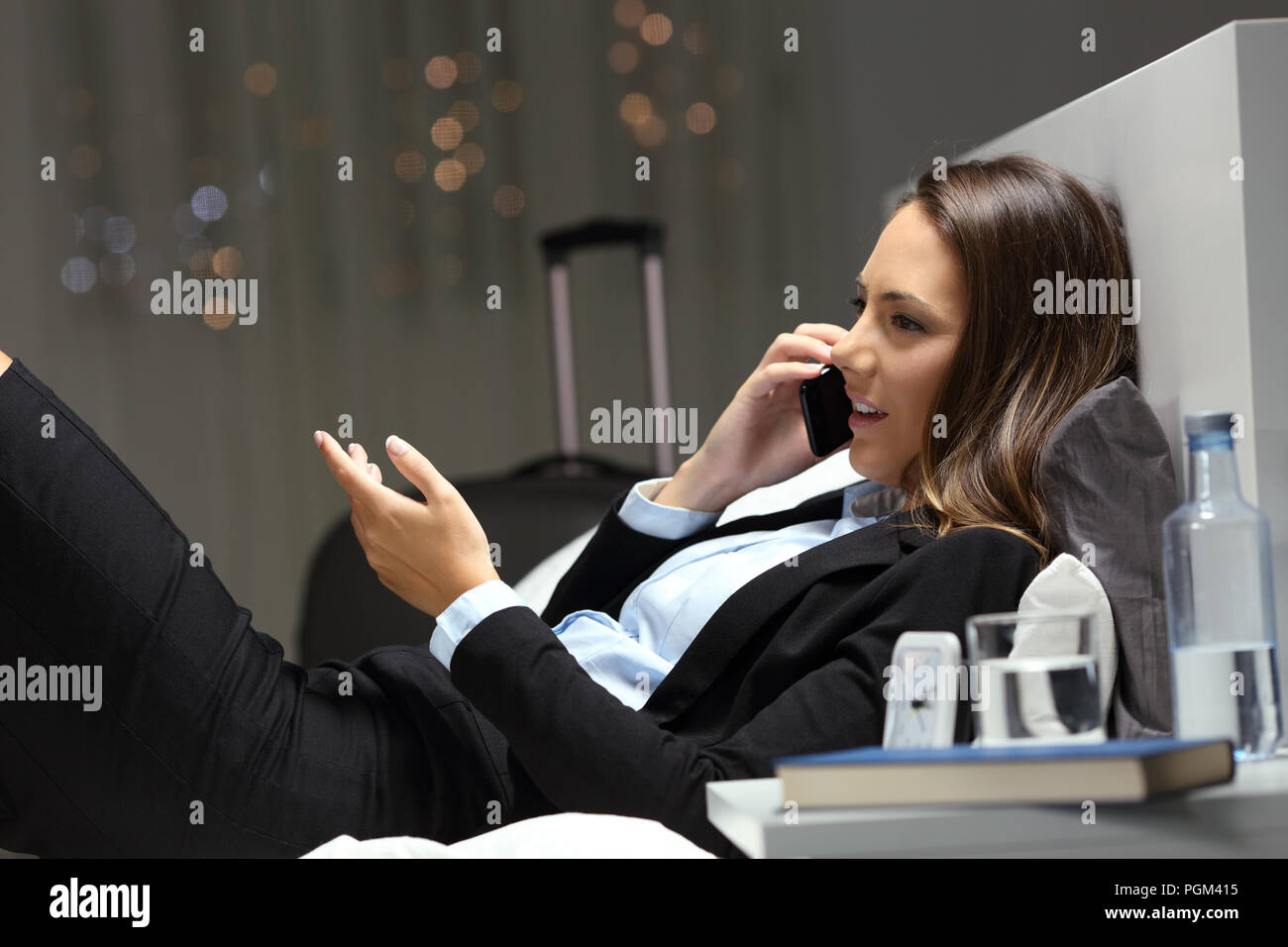 Seitenansicht Portrait Of Happy executive am Telefon sprechen während einer Geschäftsreise in einem Hotel Zimmer Stockfoto