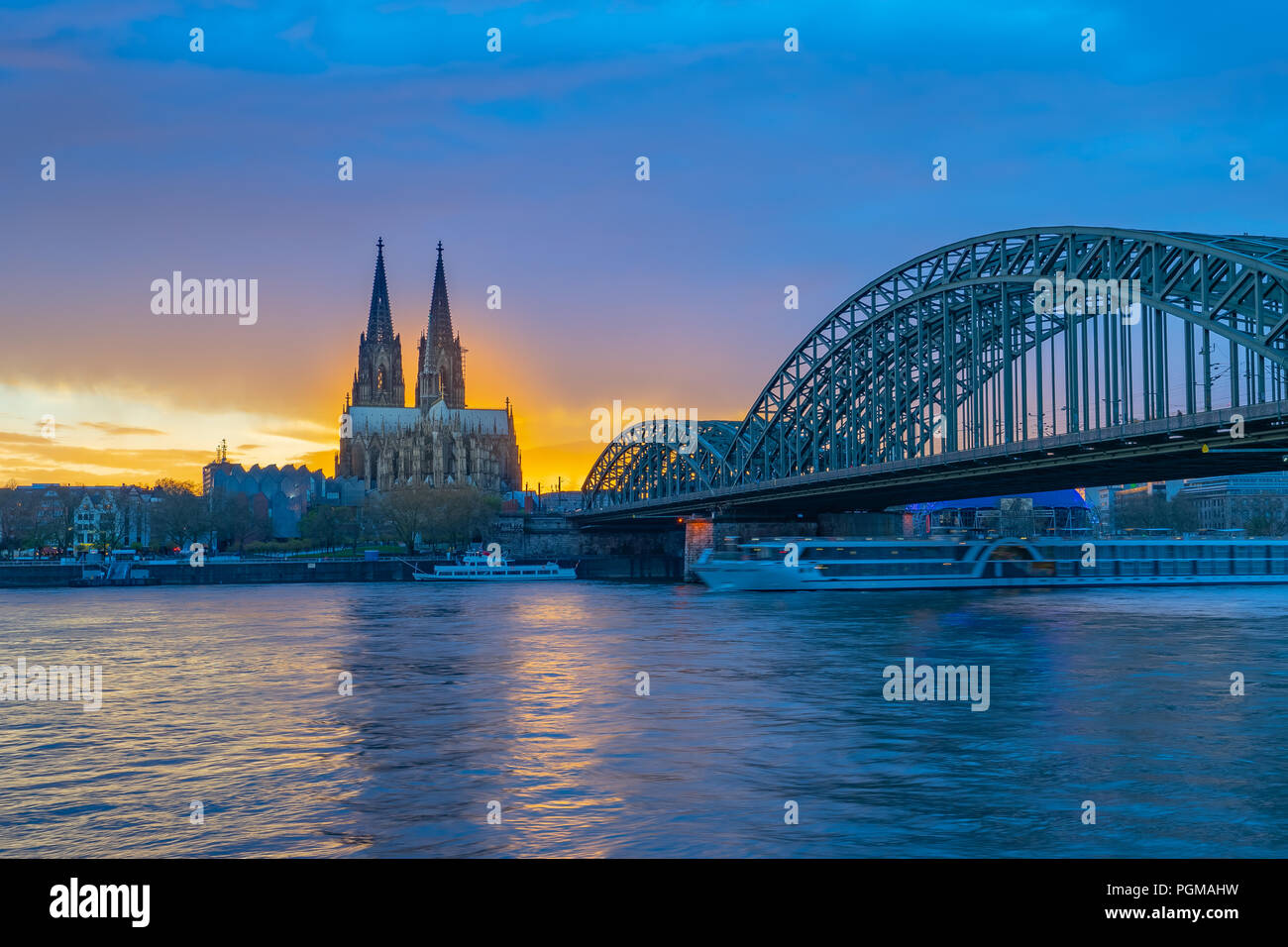 Hohenzollernbrücke mit dem Kölner Dom im Sonnenuntergang in Köln, Deutschland. Stockfoto