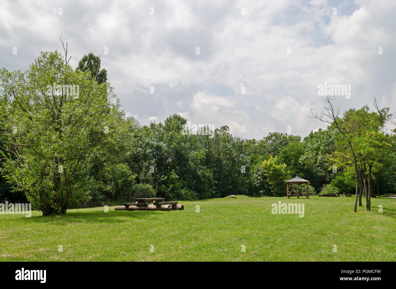 Holzbank, Alkoven und Tabelle auf einer Wiese im Wald an natürlichen Old West Park, Sofia, Bulgarien Stockfoto