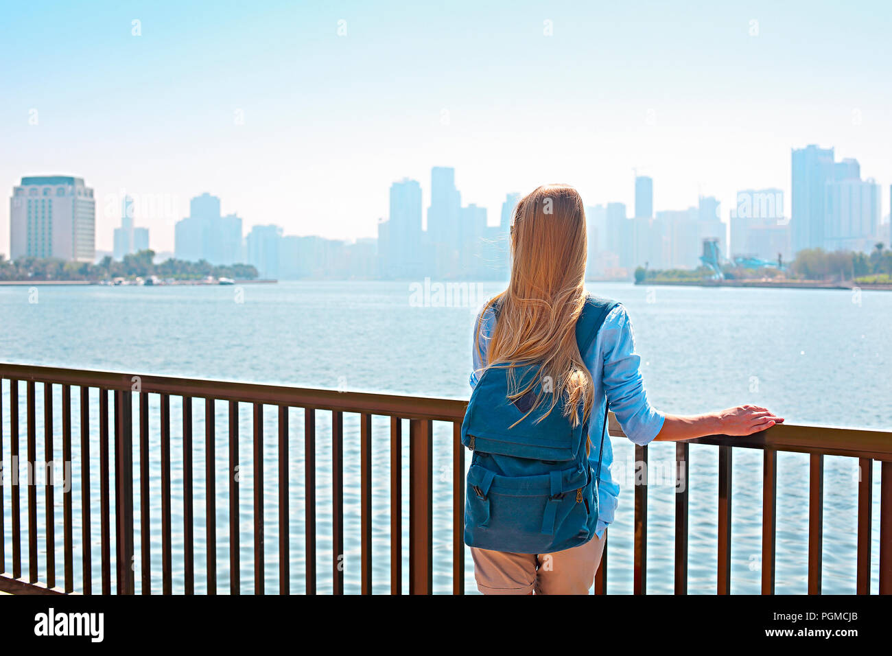 Frau Tourist mit Rucksack und Panorama von Sharjah und künstlichen See, Sharjah, VAE Stockfoto