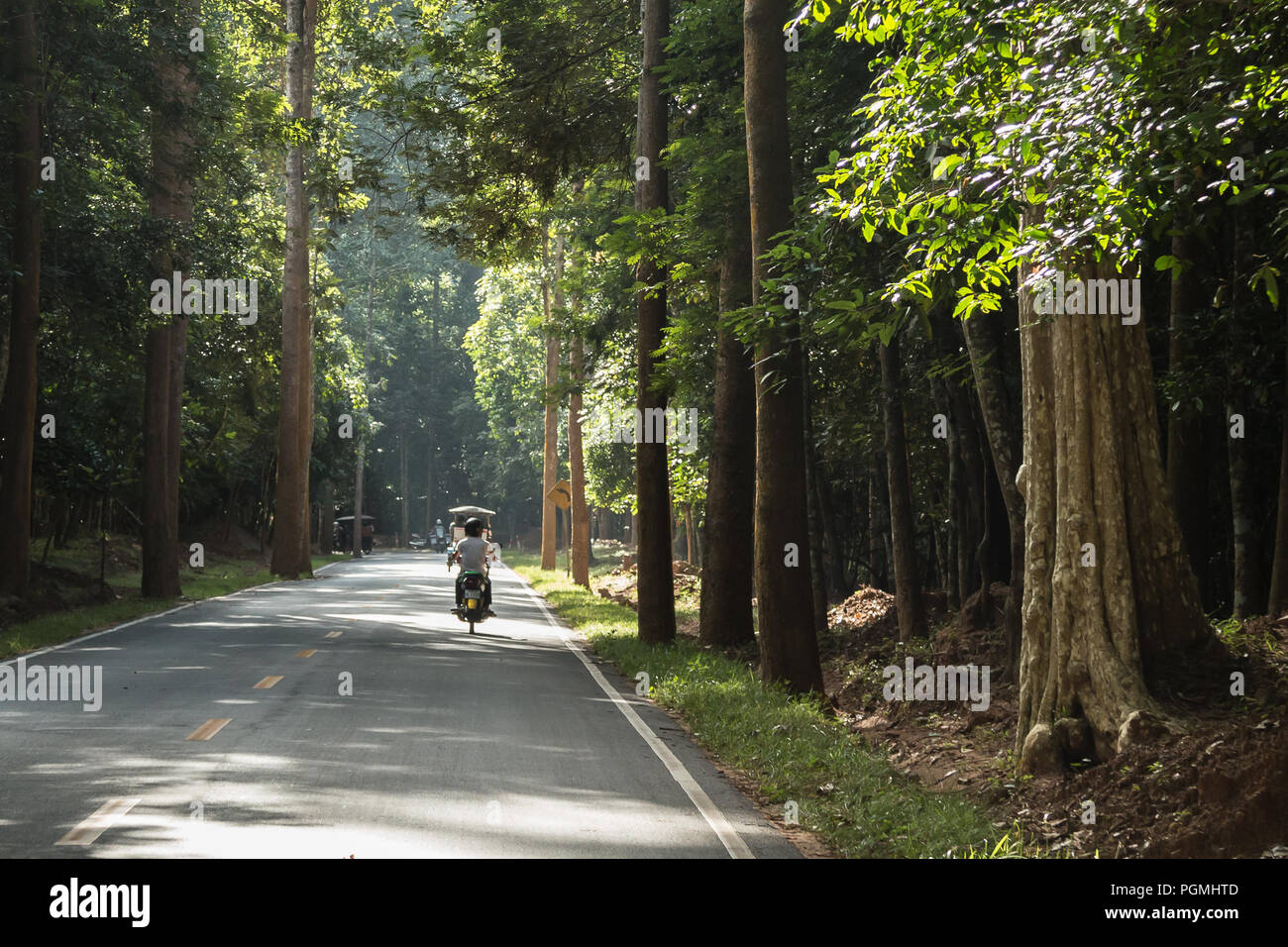 Lokale auf einem Motorrad in Angkor Archäologischer Park, in der Nähe von Siem Reap, Kambodscha Stockfoto