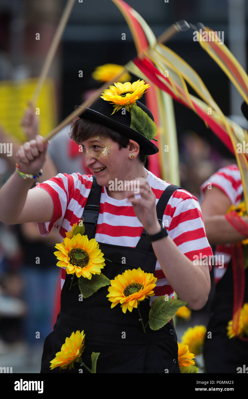 Eine Frau mit Sonnenblumen nimmt Teil an der Manchester 2018 Pride Parade. Stockfoto