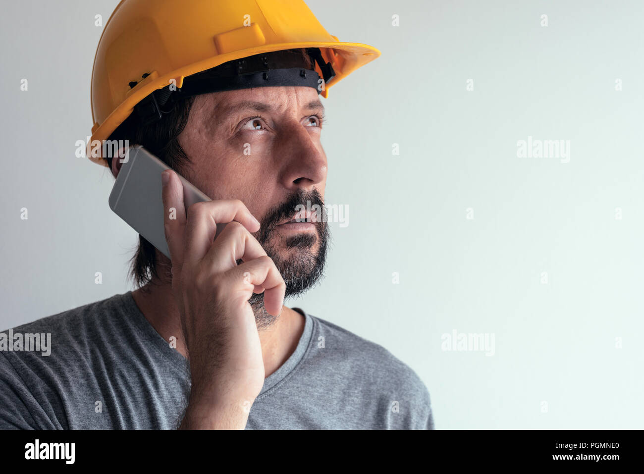 Bauingenieur Gespräch am Handy, schweren erwachsenen männlichen Person mittels Smartphone für die Kommunikation mit den Arbeitern auf der Baustelle Stockfoto