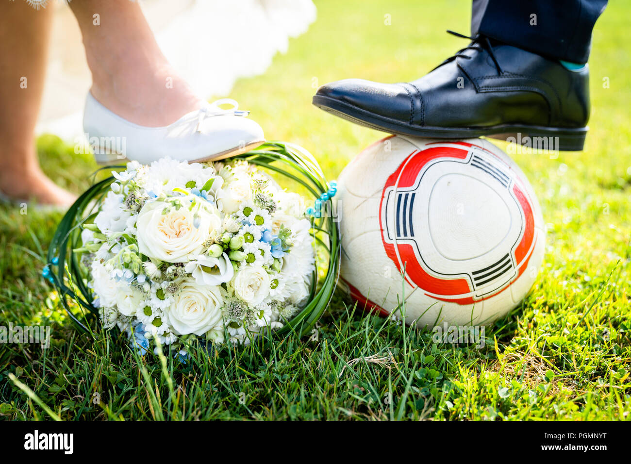 Braut und Bräutigam setzen ihre Füße auf dem Fußball Stockfoto