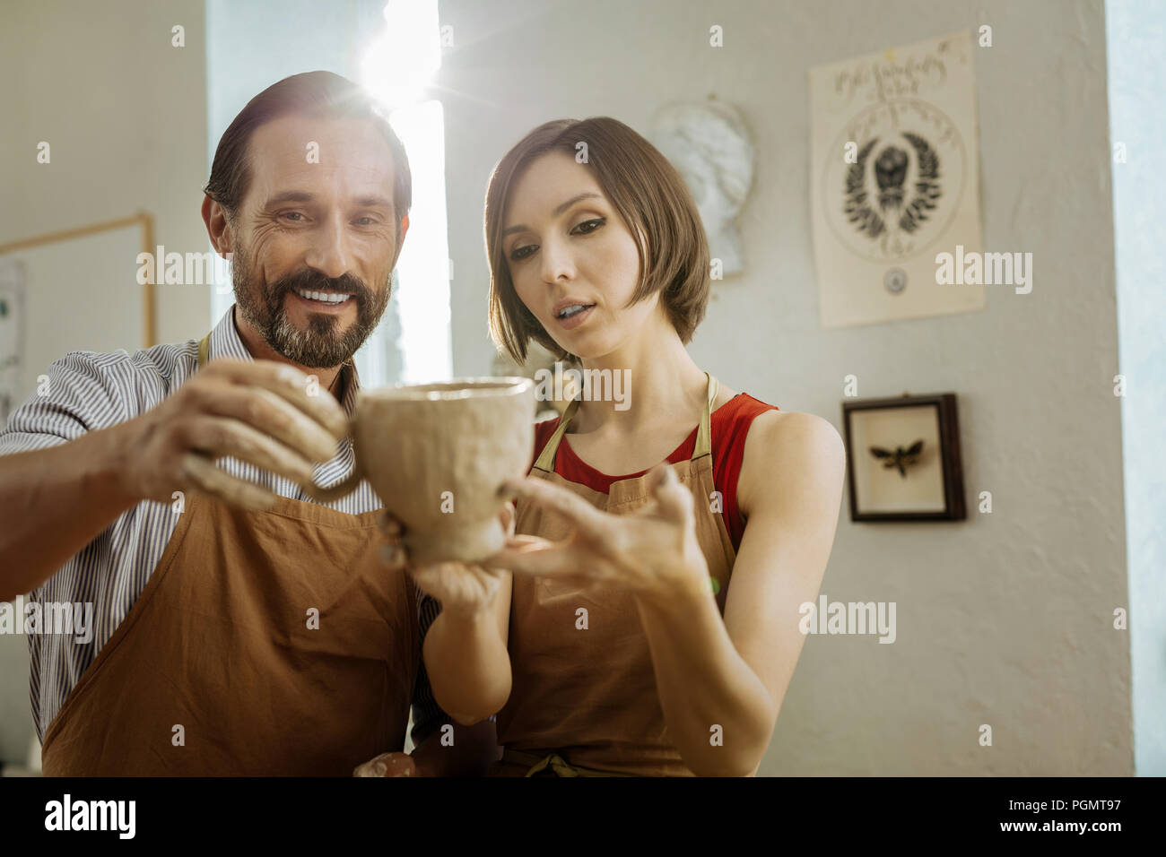 Zwei strahlende Töpfer in der Nähe der gestalteten Wand in der Werkstatt Stockfoto