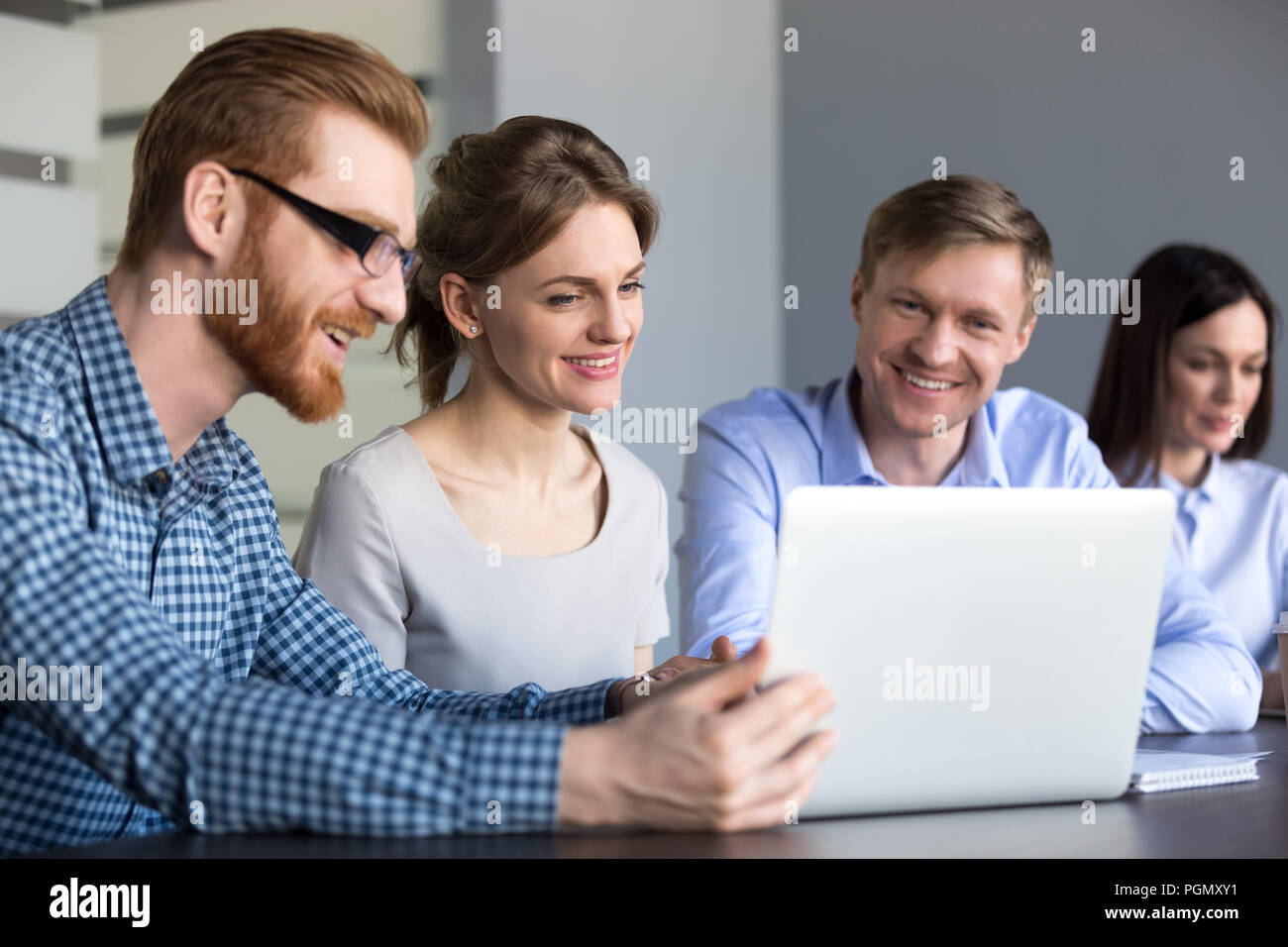 Lächelnd Arbeiter beobachten, interessante Videos mit Laptop im Büro Stockfoto