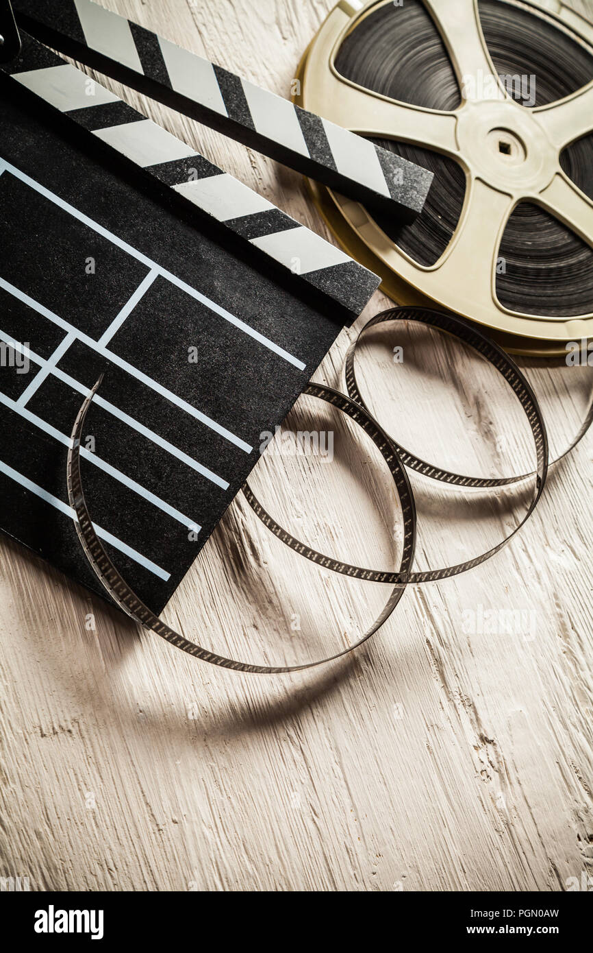 Vintage film claper mit Filmrolle auf Holz gelegt. Filmammakers Ausrüstung Hintergrund Stockfoto
