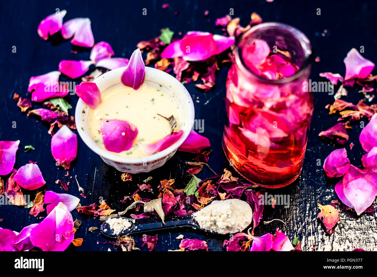Nahaufnahme von ayurvedischen und positiven face Pack für langweilig und schwarze Haut also Face pack Rose Wasser mit Gramm Mehl und einige rosa Blütenblätter auf Holz- Sur Stockfoto