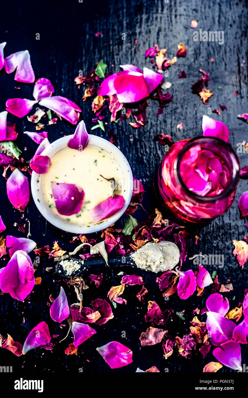 Nahaufnahme von ayurvedischen und positiven face Pack für langweilig und schwarze Haut also Face pack Rose Wasser mit Gramm Mehl und einige rosa Blütenblätter auf Holz- Sur Stockfoto