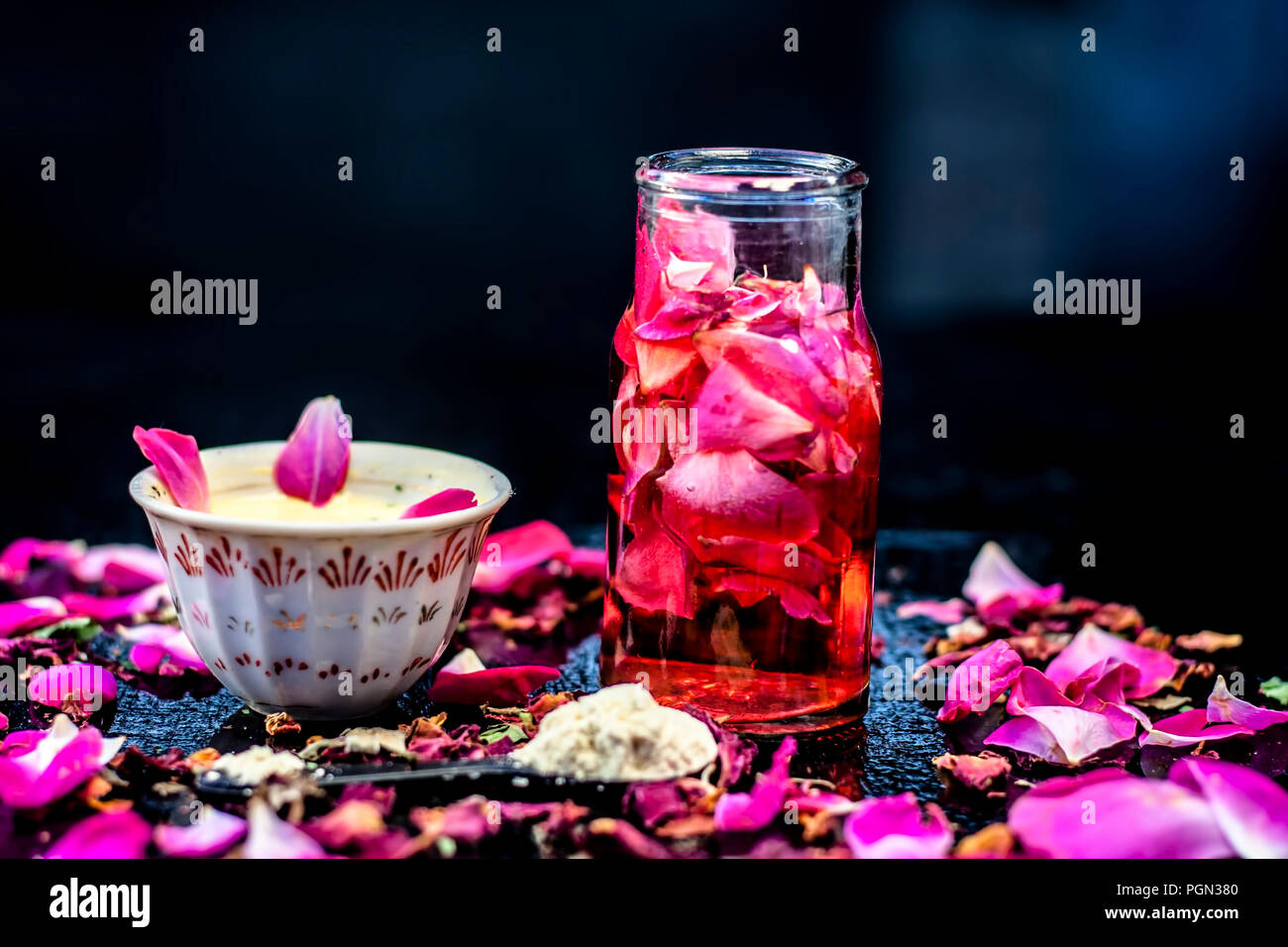 Nahaufnahme von ayurvedischen und positiven face Pack für langweilig und schwarze Haut also Face pack Rose Wasser mit Gramm Mehl und einige rosa Blütenblätter auf Holz- Sur Stockfoto