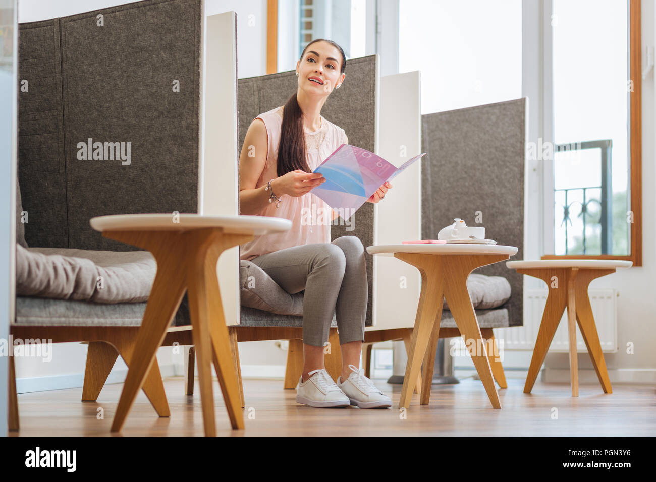 Schöne junge Frau liest eine interessante Zeitschrift Stockfoto