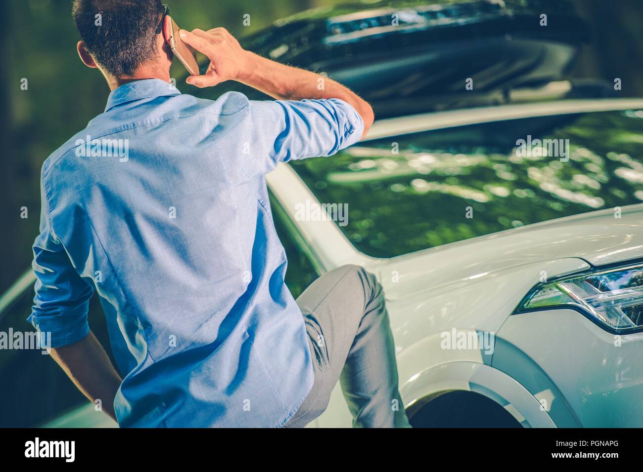 Kaukasische Fahrer einen Anruf machen Vor seinem kaputten Auto. Stockfoto
