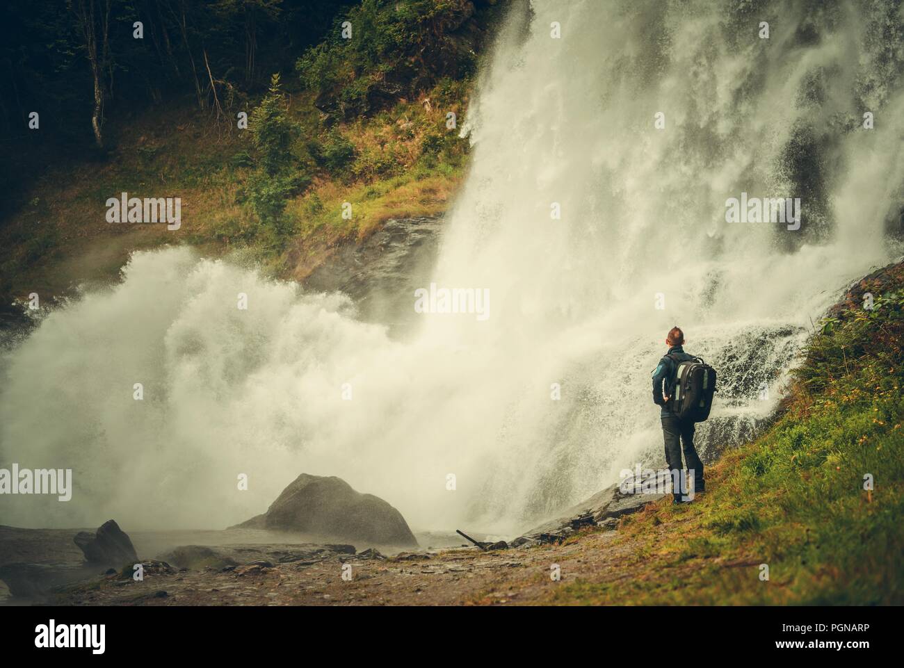 Kaukasische Wanderer und den malerischen Wasserfall. Männer mit Rucksack in die Natur. Stockfoto