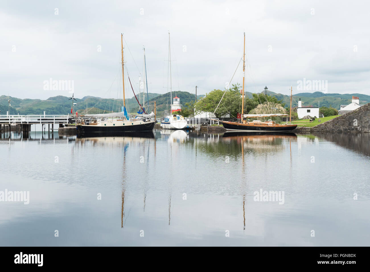 Crinan Canal Basin, Leuchtturm, Meer und Boot Reflexionen, Crinan, Argyll und Bute, Schottland, Großbritannien Stockfoto