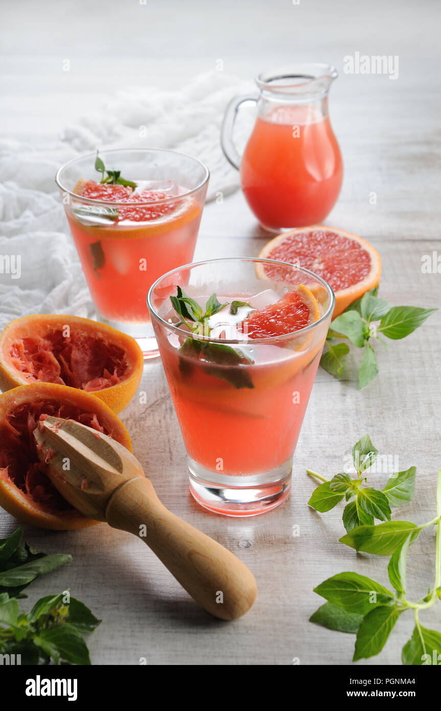 Cocktail Saft, gepressten roten Grapefruit und Blätter des zarten Basilikum Zitrone. Was könnte in einem FLIEGBAR, heissen, sonnigen Tag besser sein? Stockfoto