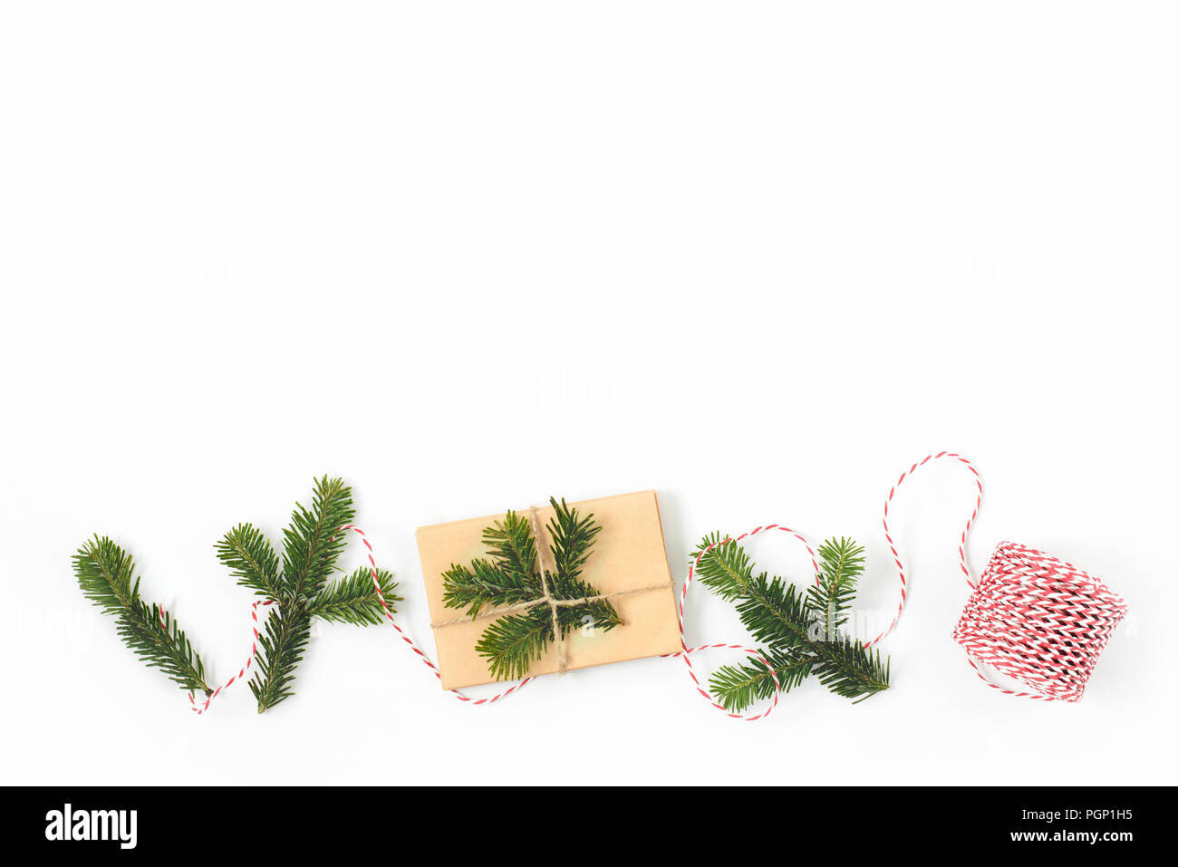 Weihnachten Geschenk verpackt in Handwerk braunes Papier und mit Fir-Zweige auf whote Hintergrund eingerichtet. Neuen Jahres Konzept geben. Kostenlose Kopie Stockfoto